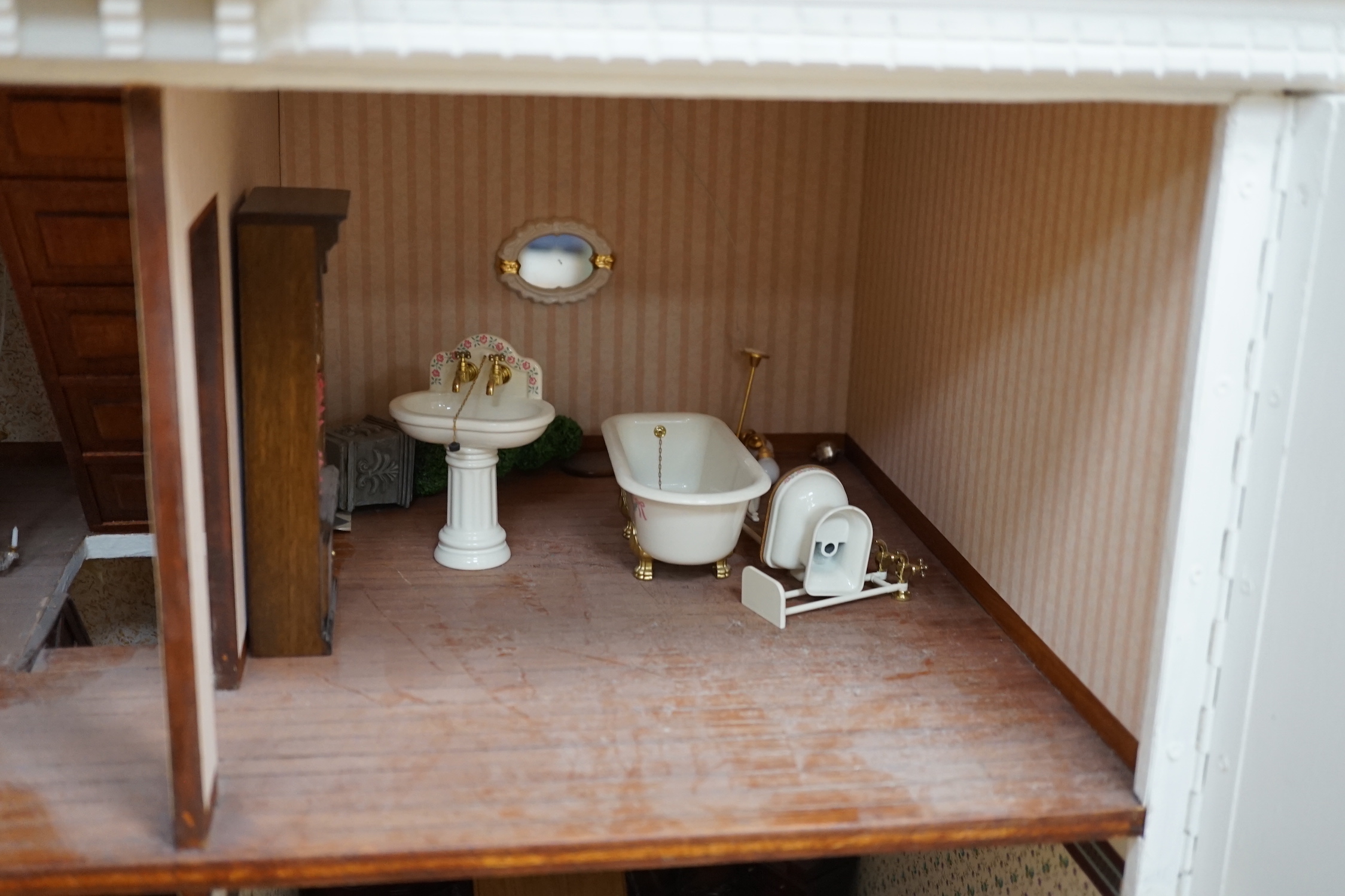 A modern Georgian style dolls house, with two front opening doors, containing six rooms with furnishings, figures, and electric lighting, together with a dolls shop, containing two rooms, furnishings, and accessories, et